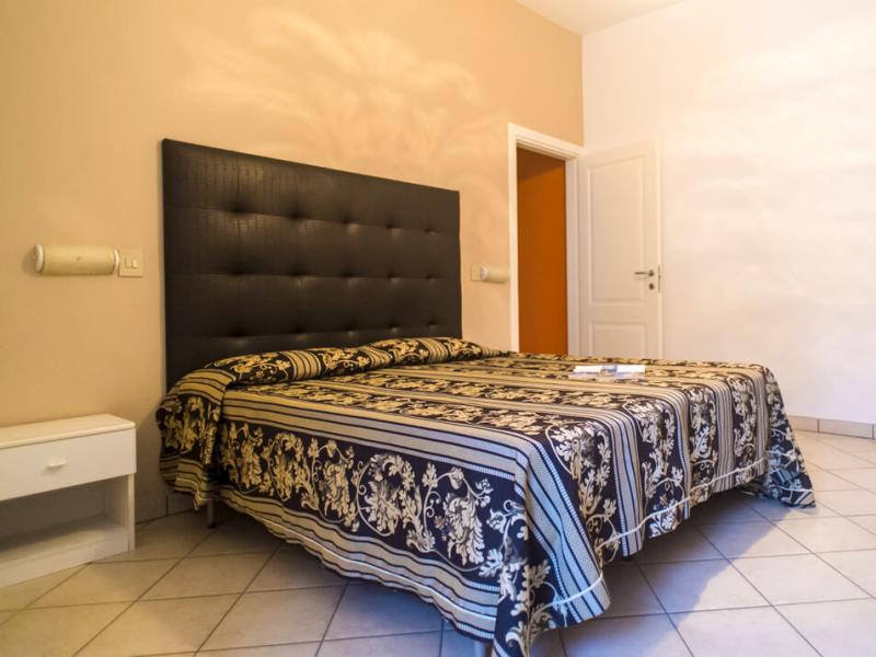 Camera da letto con letto matrimoniale e copriletto decorato.