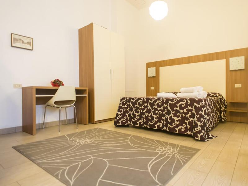 Camera moderna con letto matrimoniale e scrivania.