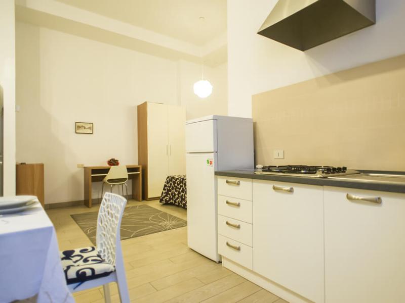 Monolocale moderno con cucina, tavolo e letto.