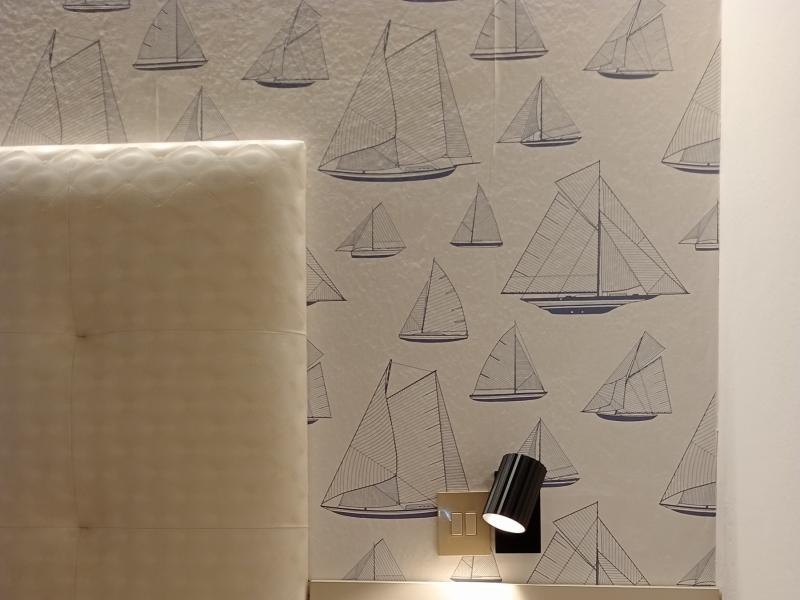 Camera da letto con decorazioni nautiche e comodino.